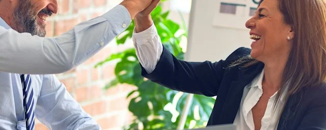 Two colleagues celebrating after switching their billing over